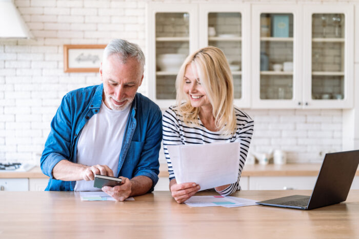 Happy mature couple buying wisely before retirement.