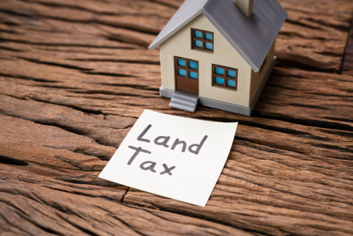 land tax post it note next to small house