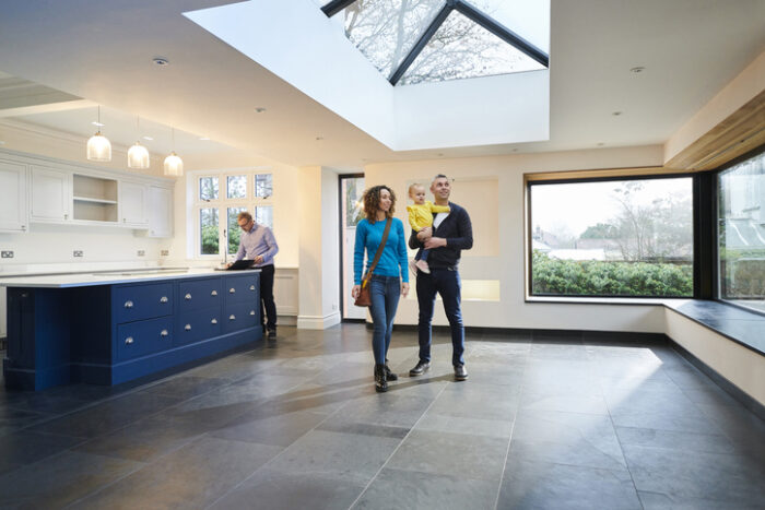 young family considering what to do with inheritance while looking round new house with estate agent