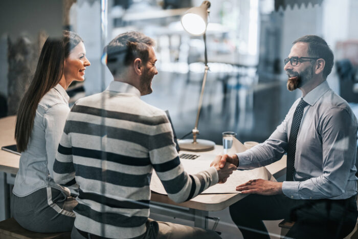 Couple shaking hands with accountant in an office after learning about tax rate on a trust