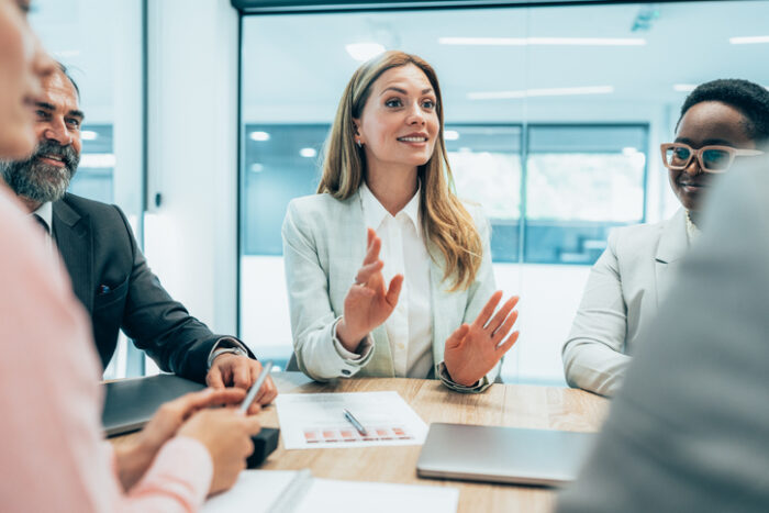 Modern business team discussing new ideas at the office. Business people on meeting in modern office. Colleagues smiling and talking at board room. Brainstorming