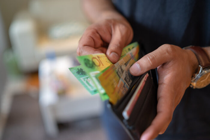 a male taking money out of the valet after February interest rate cut.