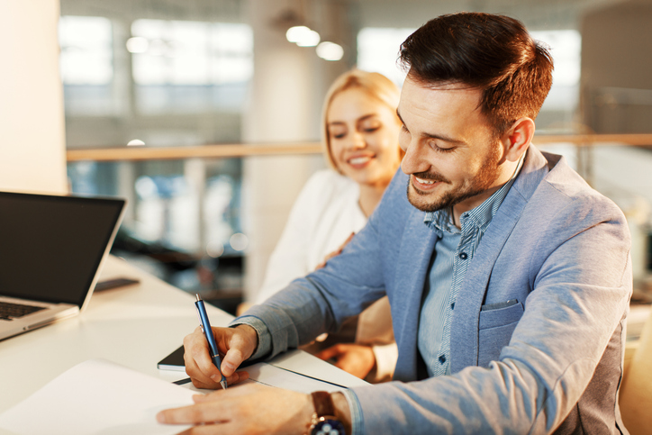 Young couple signing contract to pay down debt using inheritance