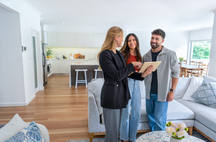 Real estate agent showing a couple a property they will purchasing using inheritance 